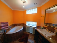 Oranžová koupelna s bílým kováním